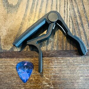 Black Guitar Capo with Purple Guitar Pick